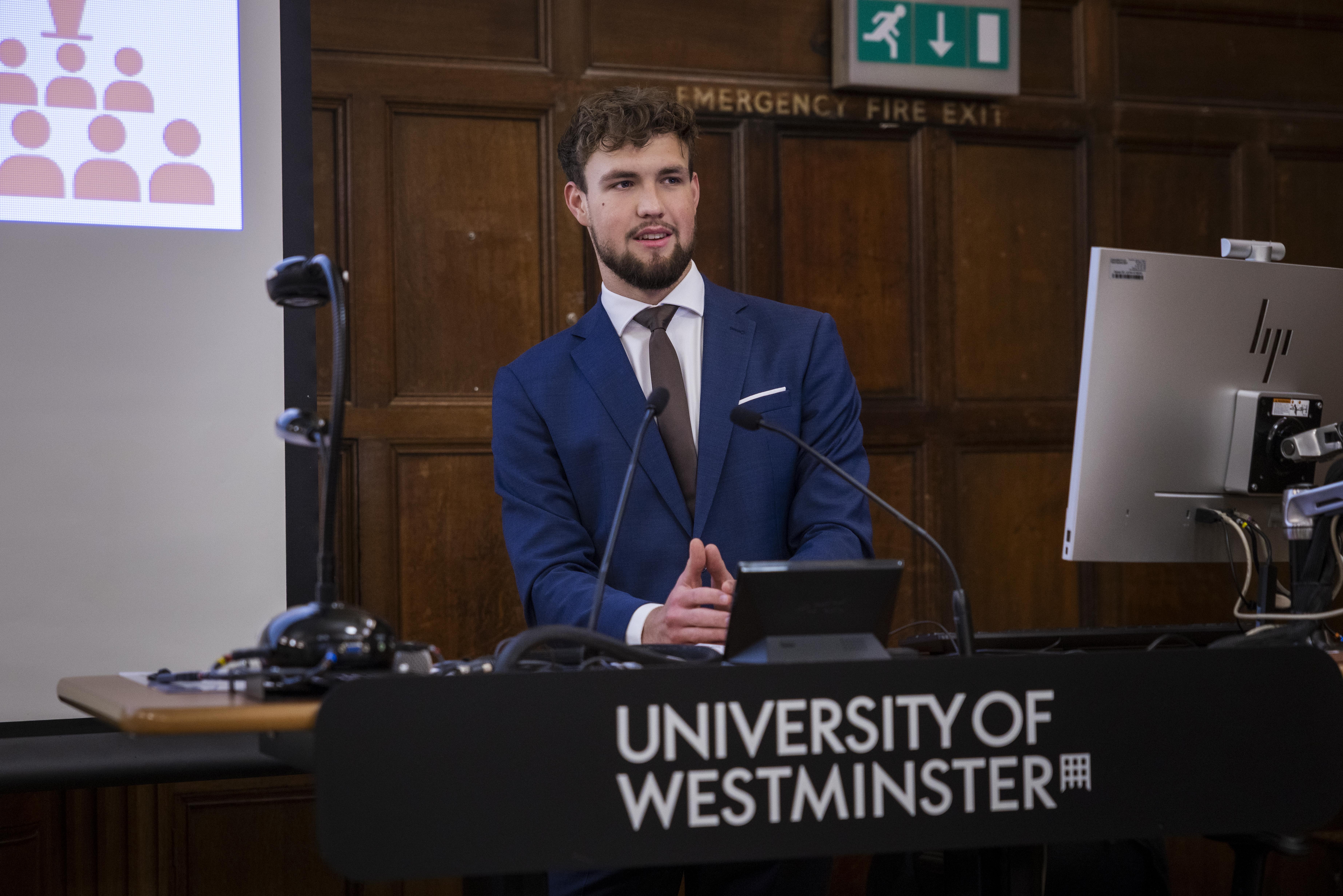 Oskar Wiśniewski za mównicą podczas konferencji w UK