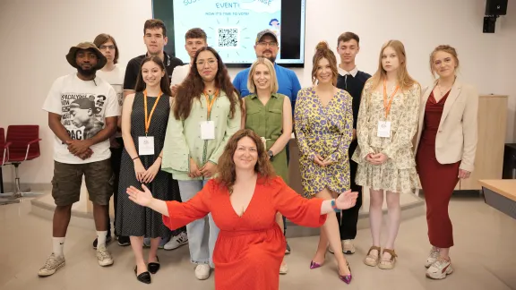 The group of participants in the event is standing and smiling at the camera.
