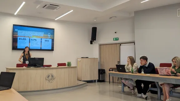 Student Irina Jalon Soloviy is standing and presenting in front of the audience