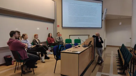 studenci biorący udział w debacie a obok nich prowadzący