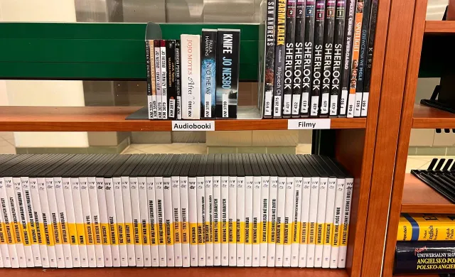 Półki z książkami na których znajdują się audiobooki i filmy DVD z napisami rozszerzonymi - zbiory Biblioteki Mokotowskiej.