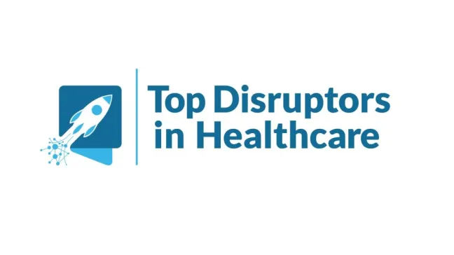 Na obrazku znajduje się niebieska rakieta w locie, która jest częścią logo. Obok niej widnieje napis w języku angielskim: "Top Disruptors in Healthcare". Tekst jest ułożony pionowo i znajduje się po prawej stronie rakiety.