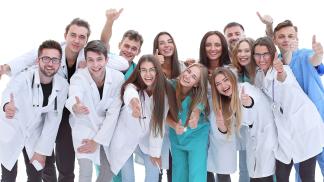 Uśmiechnięci młodzi ludzie w kitlachz kciukami do góry