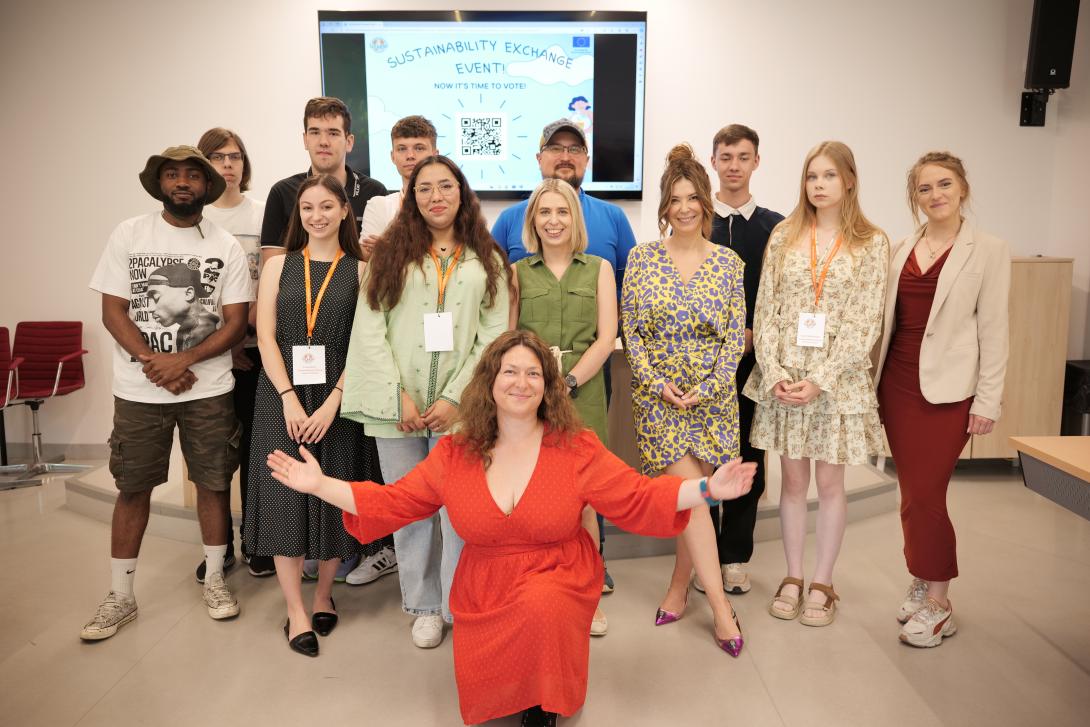 The group of participants in the event is standing and smiling at the camera.
